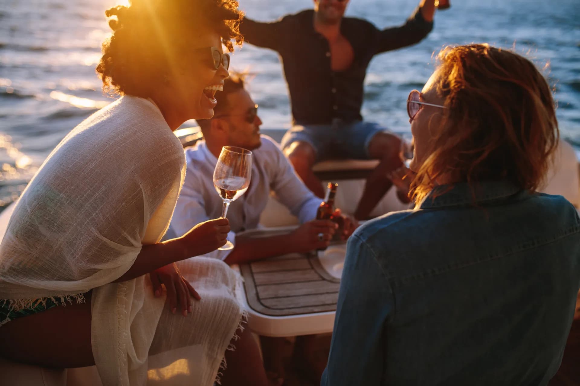 Friends laughing together on a boat at golden hour, the Saturday on the lake.