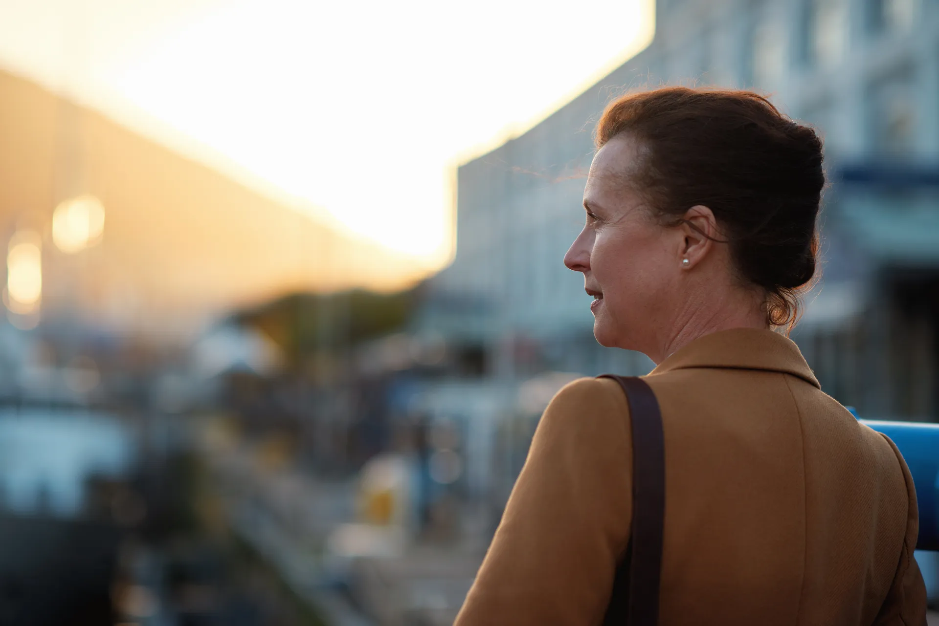 A broker looking out over the city at sunset, the whole book of business in view.